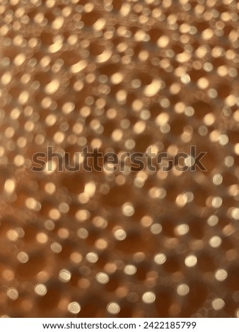 Small unsharp gold coloured lights on a bronze coloured background.