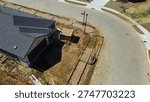 Small utility structure under assembly, rebar grids driveway framing at corner lot, Highpointe Ranch, US 377, Blackjack Rd home under construction. Shingle patterns, curved pavement, Aubrey, TX. USA