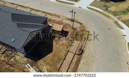 Small utility structure under assembly, rebar grids driveway framing at corner lot, Highpointe Ranch, US 377, Blackjack Rd home under construction. Shingle patterns, curved pavement, Aubrey, TX. USA