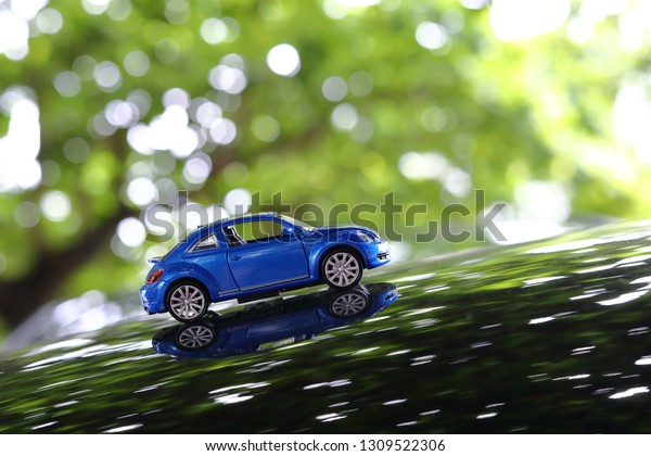 small vehicle car toy driving travel road\
trip in nature with beautiful sunlight shiny green bokeh\
background, image used retro vintage tone\
filter