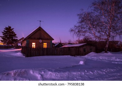 A small village house in a winter snowy moonlit night - Powered by Shutterstock