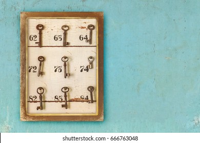 Small Vintage Cabinet With Rusted Hotel Keys And Room Numbers On A Blue Eroded Background