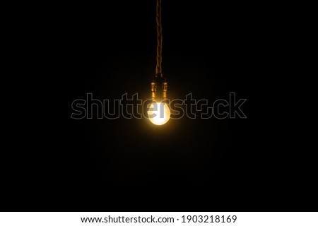 Small vintage glowing light bulb on black background. Electricity concept.