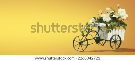 Small Vintage Tricycle Metal Planter with Flowers on Yellow and Turquoise Background and Text Space. Banner