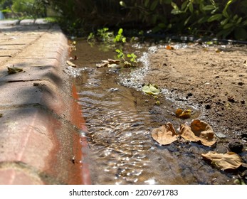 A Small Water Stream Running Between Bridges And Soils