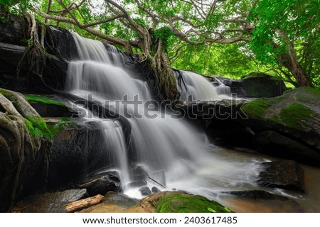 A small waterfall in the deep forest of the border of Thailand and Cambodia,ASIA.Sum sai waterfall in tropical forest,Sisaket province,Thailand. Leaf moving low speed shutter blur.
