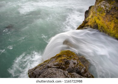 A Small Waterfall Going Over The Edge Shot From Above