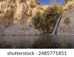 The small waterfall, little pond, and dry rocks deep in the Middle East natural oasis at Ein Gedi national reserve in Israel