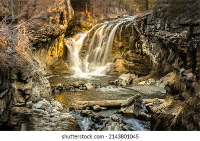 A small waterfall in the mountain cave. Cave waterfall cascade. Waterfall cascade into the cave. Cave waterfall view