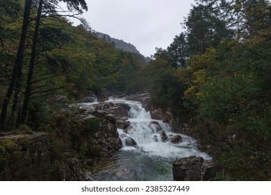 Small waterfall over rock formation and mountain river with much water during autumn time, Peneda-Geres National Park, Vilar da Veiga, Portugal