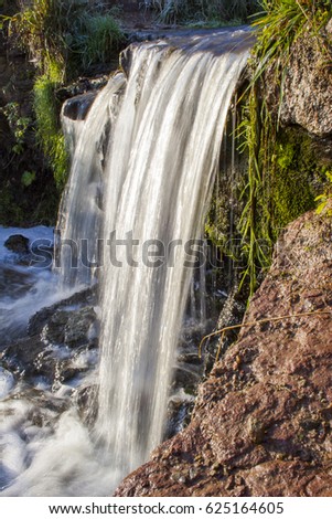 A small waterfall in the rays of the sun