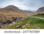 A small waterfall trickles down a stream coming out of a valley in the Tablelands area of Gros Morne National Park, Newfoundland.