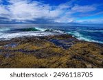 A small wave breaking on the rocky shoreline of Juan de Fuca Provincial Park on the west coast of Vancouver Island