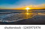 Small wave on the foreshore in Alghero at sunset. Sardinia, Italy