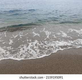 Small wave on the sandy beach. Text space. The sound of waves on the beach. white sand beach. Waves of the Mediterranean Sea. Transparent water. Beach waves background.