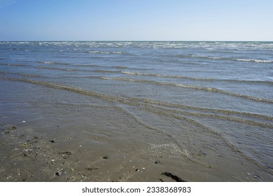 Small waves lapping up on a sandy beach