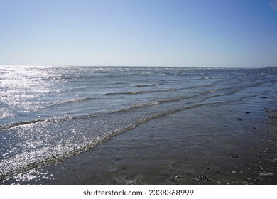 Small waves lapping up on a sandy beach