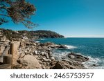 Small waves on cliff rocks in quiet Mediterranean waters seascape coastal landscape in Costa Brava, Catalonia, Mediterranean Sea