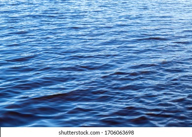 Small Waves On The Surface Of The Lake. Beautiful Texture Of Blue Water. On A Sunny Day