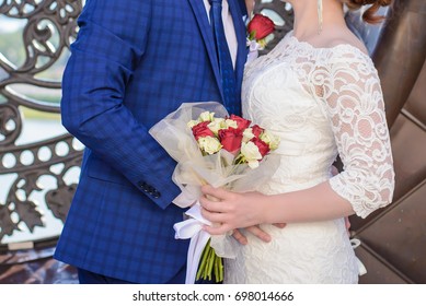 Small Wedding Bouquet Of Red And White Roses In The Hands Of The Beautiful Bride And Groom Closeup