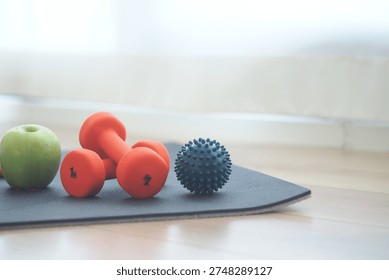 Small weights and fruit on exercise mat in living room