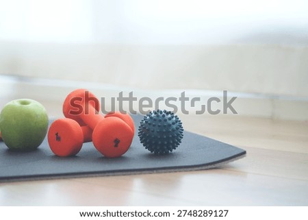 Small weights and fruit on exercise mat in living room