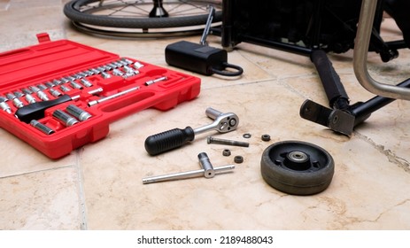 A Small Wheel From A Wheelchair Lies On The Floor Next To A Tool Kit