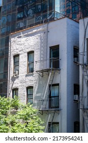 A Small White Apartment Building With An Exterior Fire Escape On Manhattan In New York City, New York, US.