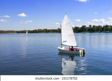 Small White Boat Sailing On The Lake On A Beautiful Sunny Day