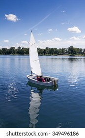 Small white boat sailing on the lake on a beautiful sunny day