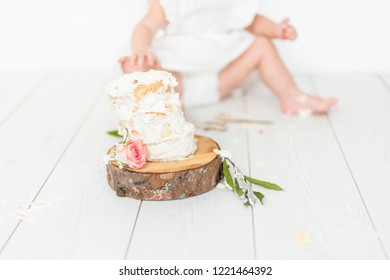 Small white cake on a wooden tray with baby