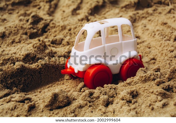Small white car rides on the\
sand