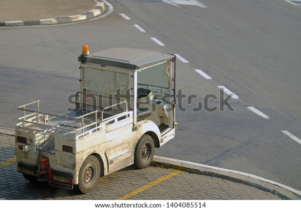 Small\
white empty truck parking on footpath beside\
road