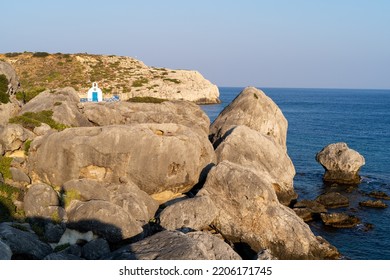 Small white Greek church on a rock by the sea - Shutterstock ID 2206171745