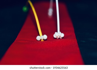 Small white objects on red textile surface