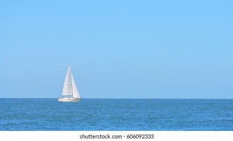 Small White Sail Yacht Sailing In Blue Sea