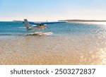 Small white seaplane with skids waiting for a sightseeing flight over  lagoon and reef and the rock "Le Morne" on the coast of Mauritius (Indian Ocean, Africa). Tourists can enjoy aerial views.