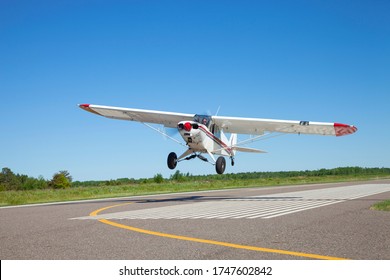 Small white single engine airplane takes off from a municipal airfield in rural Minnesota - Powered by Shutterstock