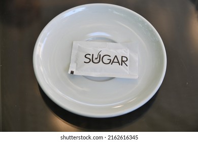 Small White Sugar Pack On A Coffee Tea White Plate  