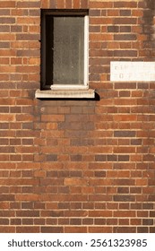 A small window located in the brick facade of a building in London