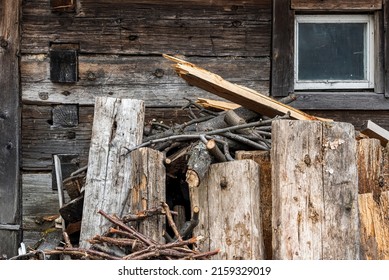 a small window on the wall of an old wooden house, old firewood stacked next to it. copy space.