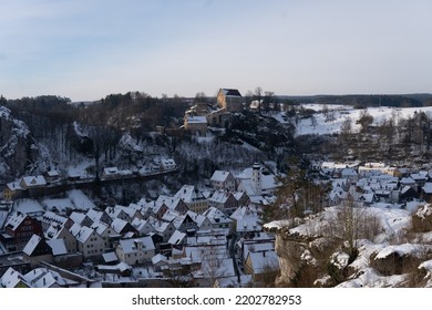 Small Winter Town Covered In Snow In Front Of Castle On A Hill
