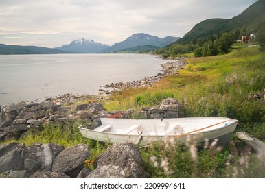 A Small Wooden Boat In The Shore Of A Lake In Lofoten Islands, Norway