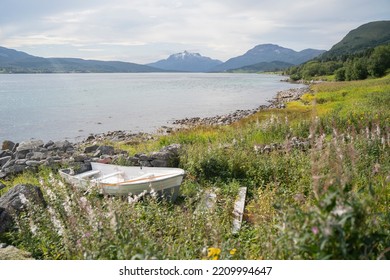 A Small Wooden Boat In The Shore Of A Lake In Lofoten Islands, Norway