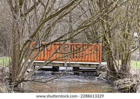 Small wooden bridge over a stream in spring