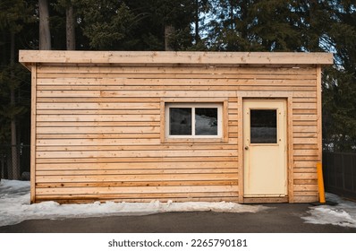 Small wooden cabin house in the evening. Exterior design. Small house for vacation. Log cabin in a forest in the winter. Travel photo, nobody - Powered by Shutterstock