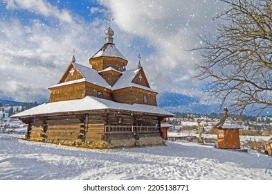 Small Wooden Church. Christmas Eve During Snowfall, Ancient Folk Architecture. Wallpaper With New Year's Mood