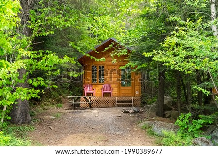 Small wooden cottage among trees for camping