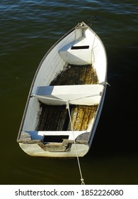 A Small Wooden Dinghy On The Beach