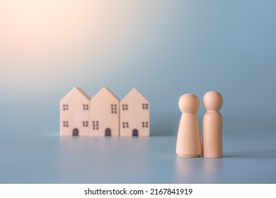 Small Wooden Faceless Figures Of Human Family Members And House. Property, Hospitality, Orphanage Concept Using Wooden House And Human Model.